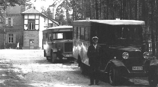 Historisches Foto des Gründers von Auto Webel vor einem alten Bus
